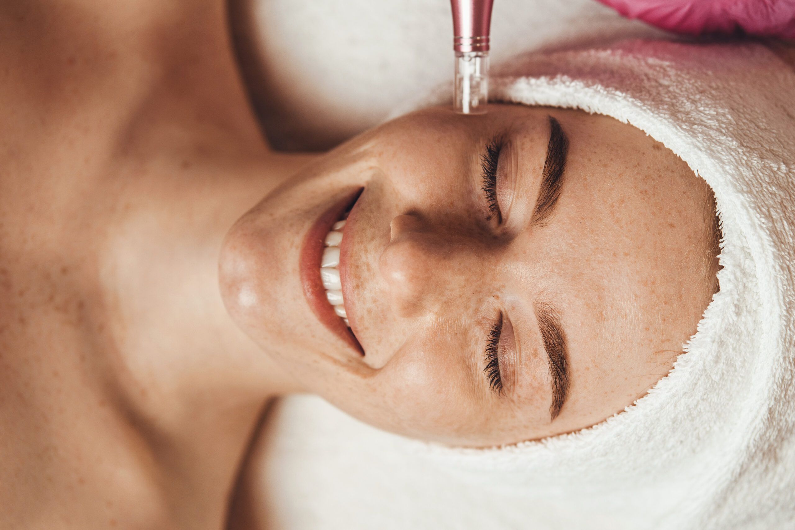 A woman who is laying down having a facial procedure.